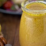 honey lemon vinaigrette dressing in a jar by a salad