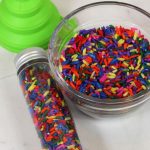 rainbow rice mini sensory bottle and rainbow rice in a bowl
