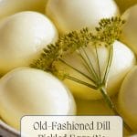 A bowl of whole Dill Pickled Eggs soaking in yellow dill brine, garnished with a sprig of dill. Text reads: "Old-Fashioned Dill Pickled Eggs (No Canning Required).